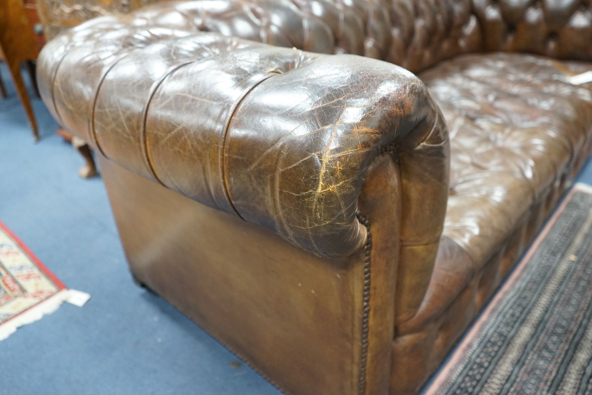 An early 20th century Chesterfield settee upholstered in deep buttoned brown leather, length 200cm, depth 90cm, height 72cm